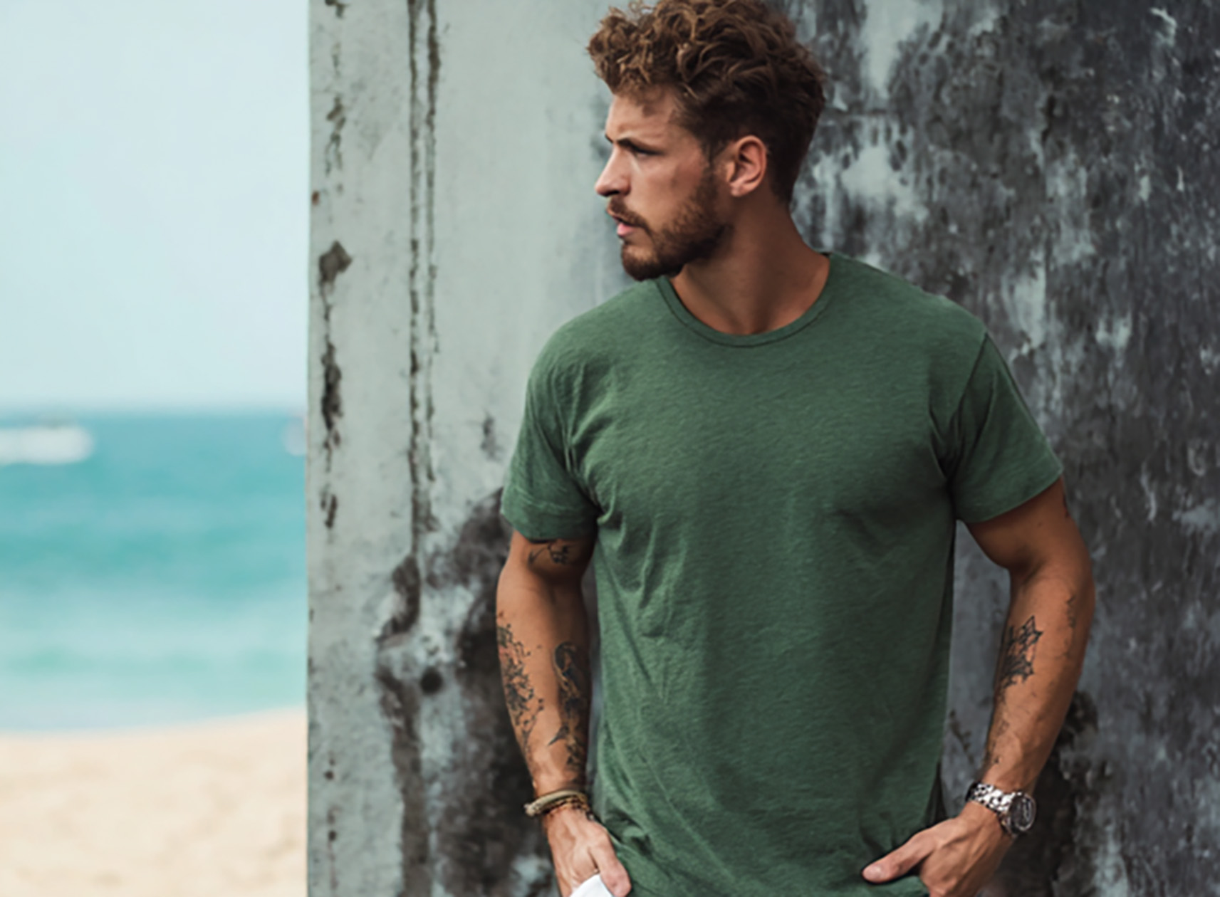Homem vestindo camiseta verde exército Aeris com o mar ao fundo